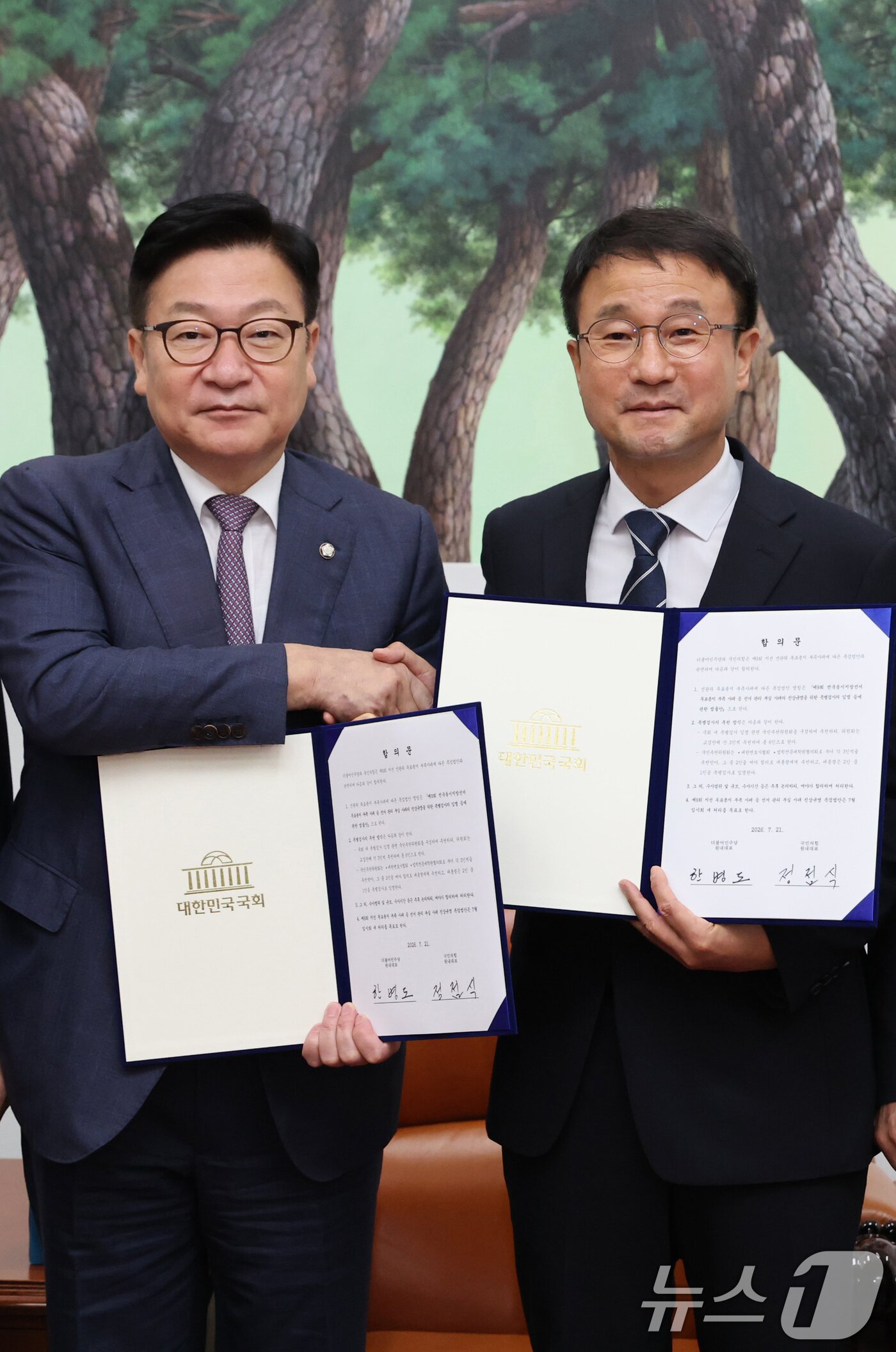 본문 이미지 - 한병도 더불어민주당 대표 직무대행 겸 원내대표와 정점식 국민의힘 원내대표가 21일 서울 여의도 국회 운영위원장실에서 제9회 전국동시지방선거 투표용지 부족 사태 등 선거관리 부실 사태의 진상규명을 위한 특별검사의 임명 등에 관한 법률안 합의문에 서명한 후 악수하고 있다. (공동취재) 2026.7.21 ⓒ 뉴스1 신웅수 기자
