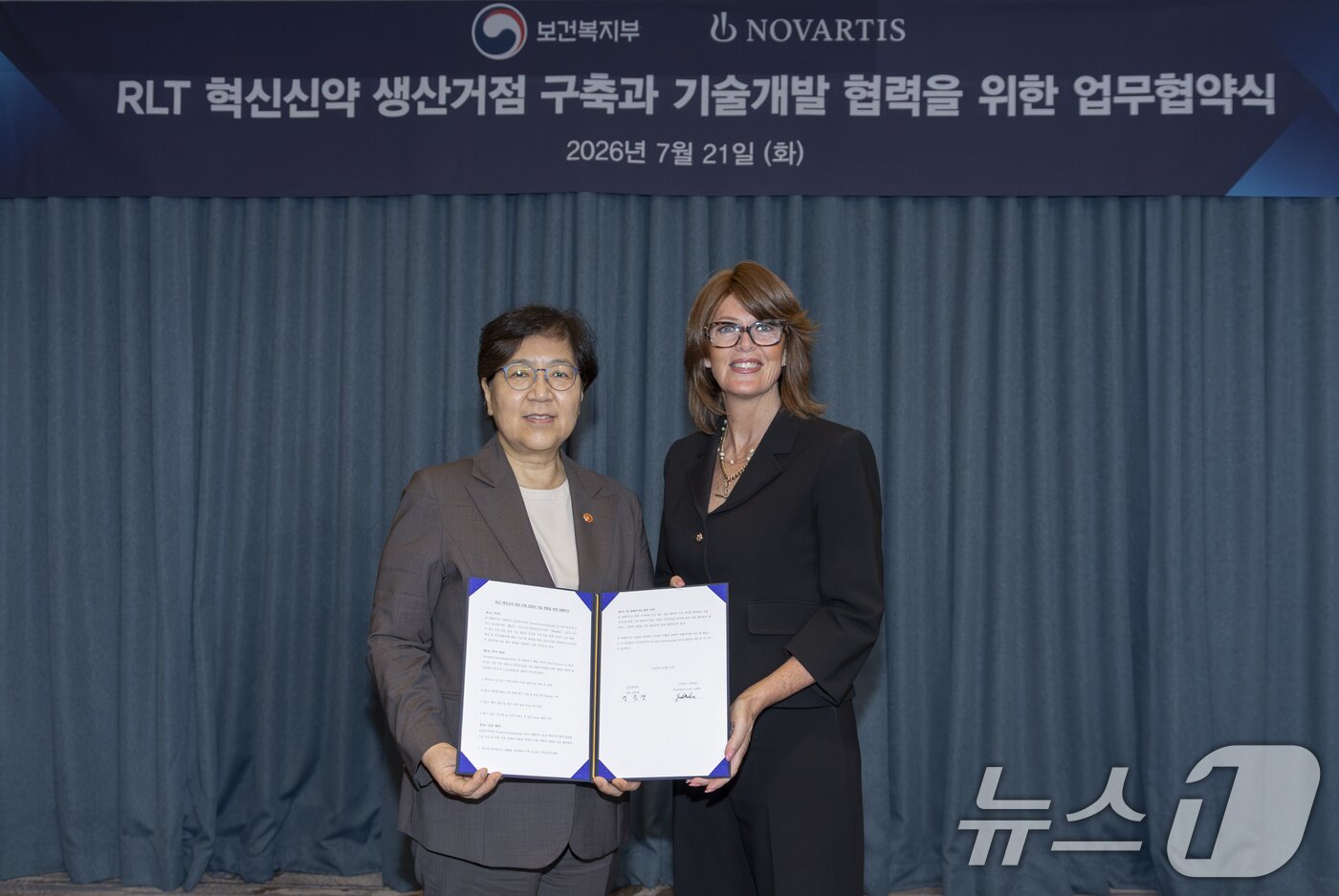 본문 이미지 - 정은경 보건복지부 장관과 글로벌 제약기업 '노바티스'의 주디스 러브 APMA(아시아·태평양·중동·아프리카 지역) 총괄 사장이 21일 서울 용산 노보텔 앰버서더 호텔에서 한국 내 방사선 리간드 치료제(RLT) 생태계 조성을 위한 양해각서(MOU)를 체결하고 있다. 노바티스는 국내에 방사성 리간드 치료제(RLT) 공급망 구축에 1400억 원 규모의 투자에 나선다. (보건복지부 제공. 재판매 및 DB금지) 2026.7.21 ⓒ 뉴스1