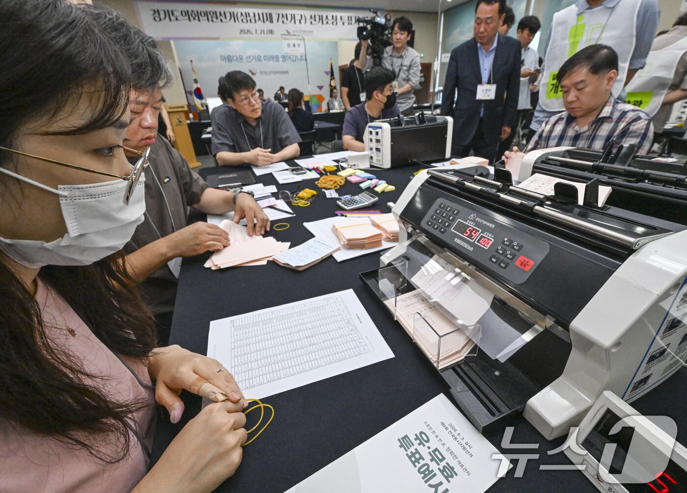 본문 이미지 - 21일 경기 수원시 영통구 경기도선거관리위원회에서 열린 '성남시 제7선거구 경기도의원 선거 및 당선무효소청 투표지 검증'에서 양측 참관인들이 지켜보는 가운데 도 선관위 관계자들이 투표지 검증을 하고 있다. (공동취재) 2026.7.21 ⓒ 뉴스1 김영운 기자