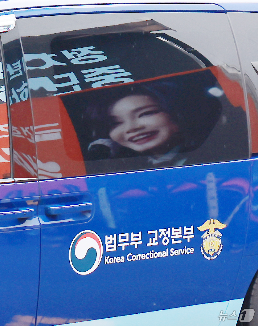 (과천=뉴스1) 이호윤 기자 = 김건희 여사를 태운 호송차가 22일 경기 과천 2차 종합특검 사무실 지하주차장으로 들어서고 있다. 김여사가 탄 차량에 지지자들이 마련한 김 여사 사 …