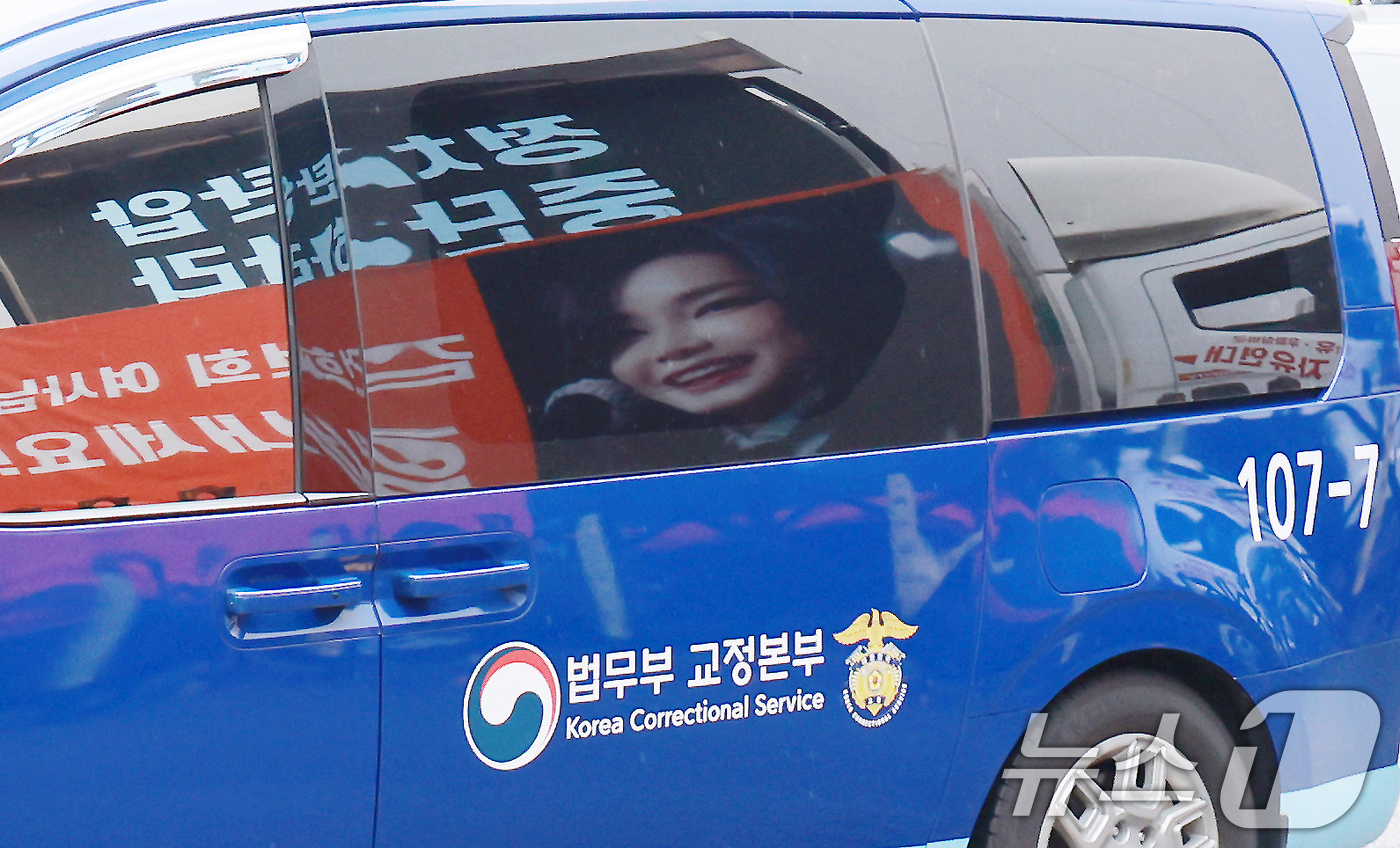 (과천=뉴스1) 이호윤 기자 = 김건희 여사를 태운 호송차가 22일 경기 과천 2차 종합특검 사무실 지하주차장으로 들어서고 있다. 김여사가 탄 차량에 지지자들이 마련한 김 여사 사 …