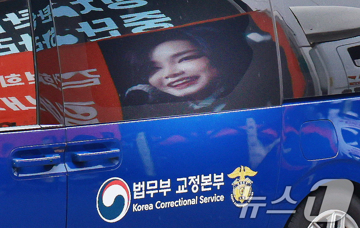 (과천=뉴스1) 이호윤 기자 = 김건희 여사를 태운 호송차가 22일 경기 과천 2차 종합특검 사무실 지하주차장으로 들어서고 있다. 김여사가 탄 차량에 지지자들이 마련한 김 여사 사 …