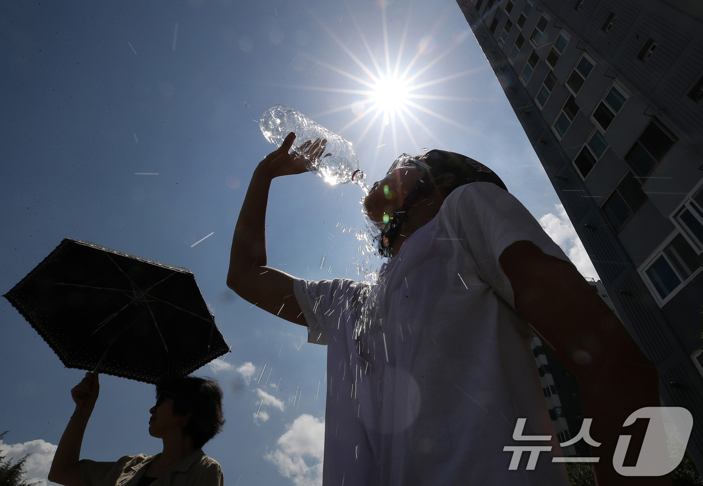 (대구=뉴스1) 공정식 기자 = '염소뿔도 녹인다'는 절기 대서(大暑)를 하루 앞둔 22일 오전부터 대구 전역에 폭염경보가 발효된 가운데 달구벌대로에서 자전거를 타던 시민이 물을 …