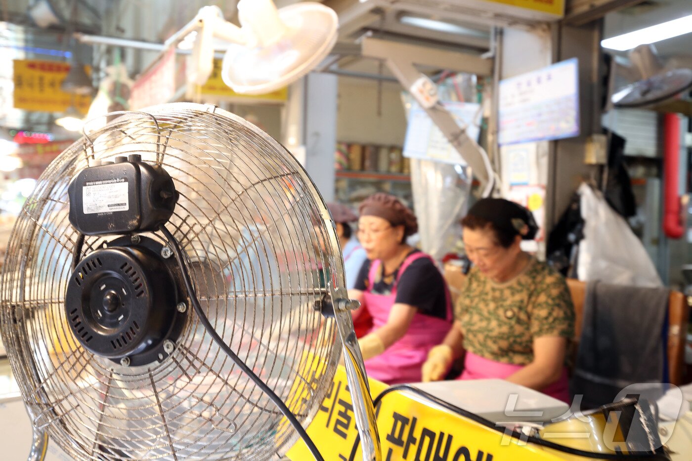 본문 이미지 - 22일 오후 전남광주통합특별시 서구 양동 양동시장에서 폭염 속 상인들이 선풍기를 틀며 음식 준비를 하고 있다. 2026.7.22 ⓒ 뉴스1 조수민 기자