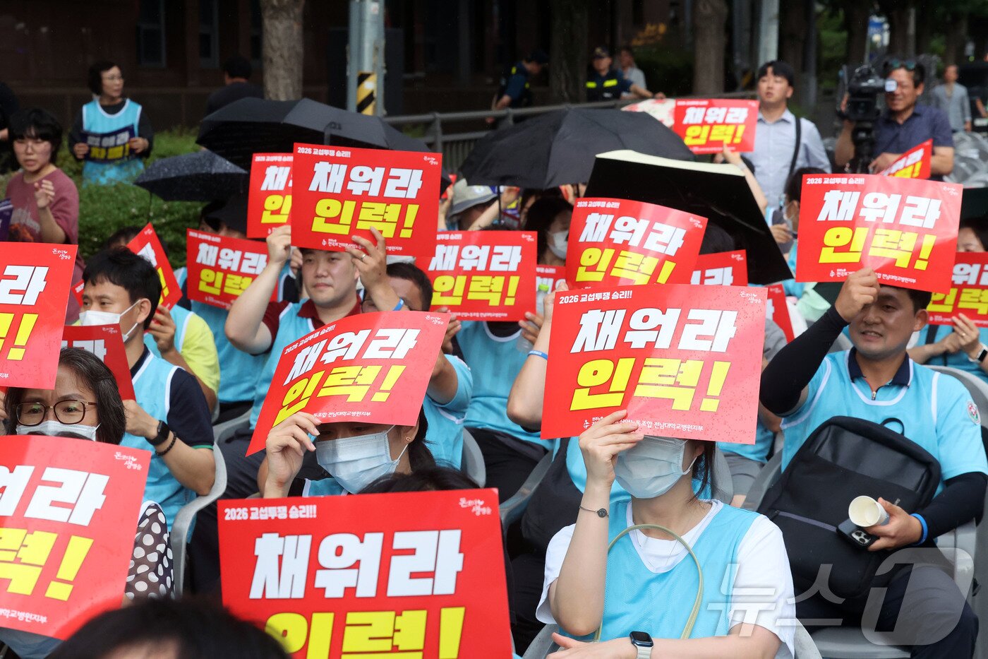 본문 이미지 - 22일 오후 전남광주통합특별시 동구 전남대병원 오거리에서 열린 전남대병원지부 파업전야제에서 조합원들이 피켓을 들고 있다. 2026.7.22 ⓒ 뉴스1 조수민 기자