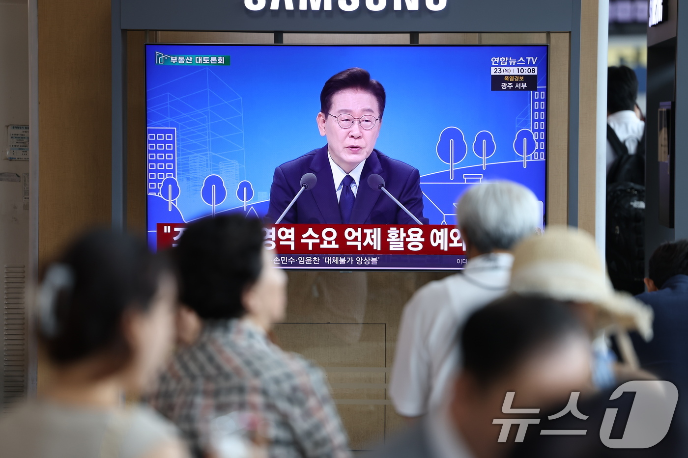 (서울=뉴스1) 이종수 기자 = 23일 오전 서울역 대합실에서 시민들이 이재명 대통령이 주재하는 부동산 대토론회 TV 생중계를 시청하고 있다. 2026.7.23/뉴스1