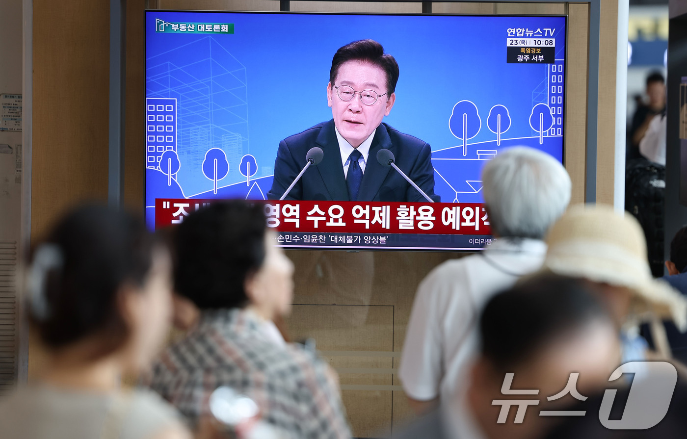 (서울=뉴스1) 이종수 기자 = 23일 오전 서울역 대합실에서 시민들이 이재명 대통령이 주재하는 부동산 대토론회 TV 생중계를 시청하고 있다. 2026.7.23/뉴스1