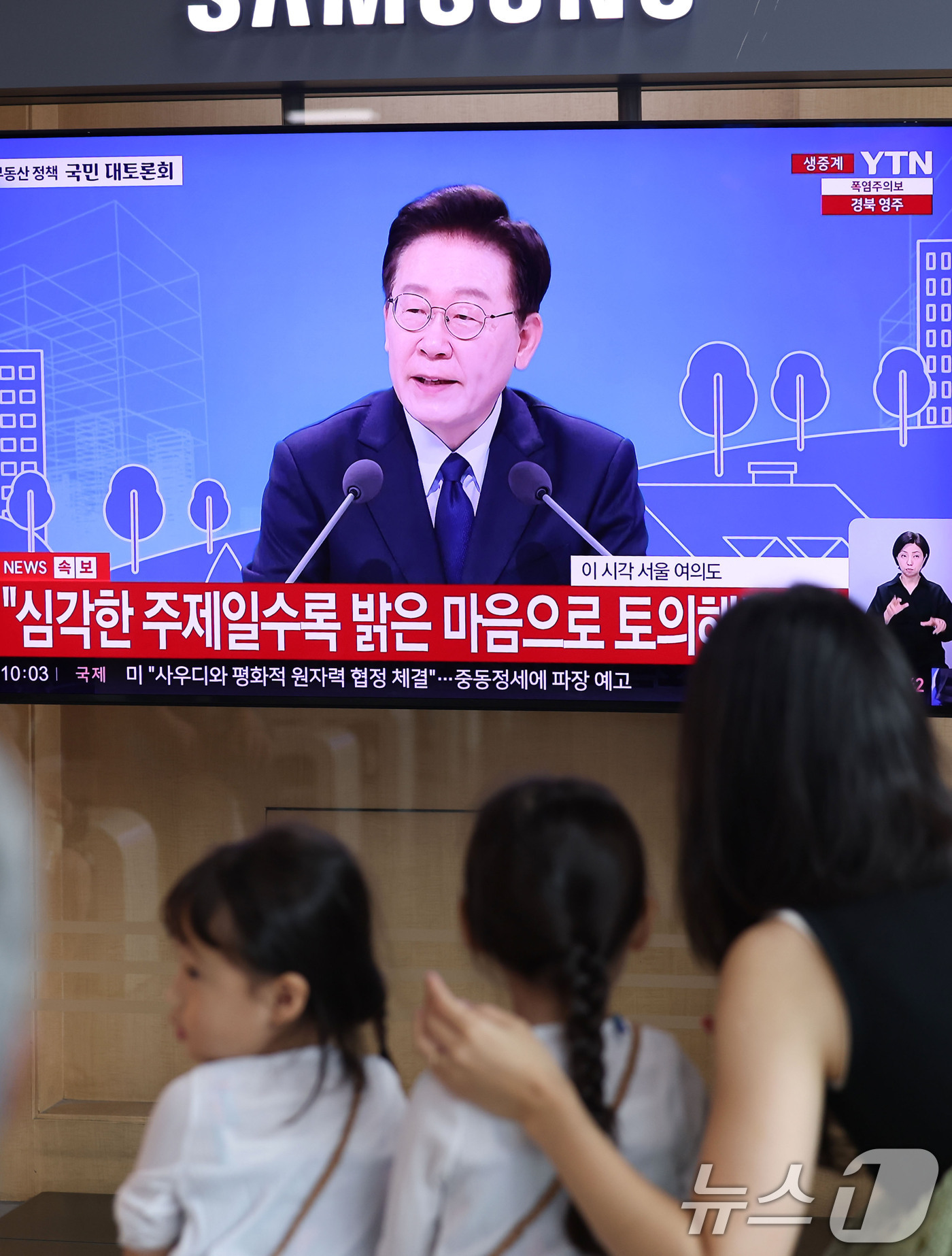 (서울=뉴스1) 이종수 기자 = 23일 오전 서울역 대합실에서 시민들이 이재명 대통령이 주재하는 부동산 대토론회 TV 생중계를 시청하고 있다. 2026.7.23/뉴스1