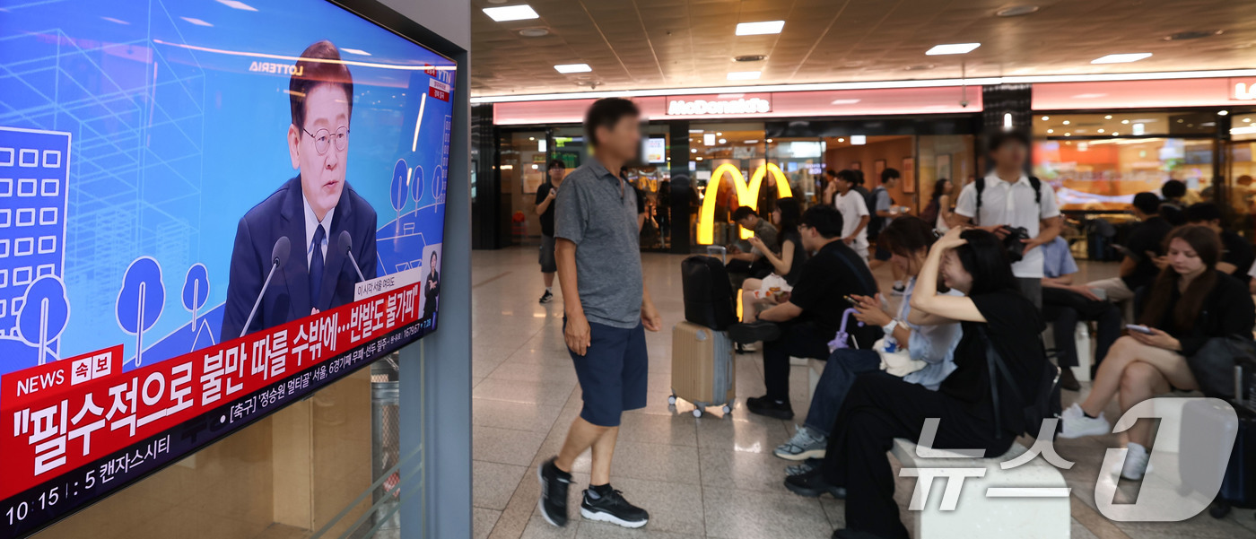 (서울=뉴스1) 이종수 기자 = 23일 오전 서울역 대합실에서 시민들이 이재명 대통령이 주재하는 부동산 대토론회 TV 생중계를 시청하고 있다. 2026.7.23/뉴스1