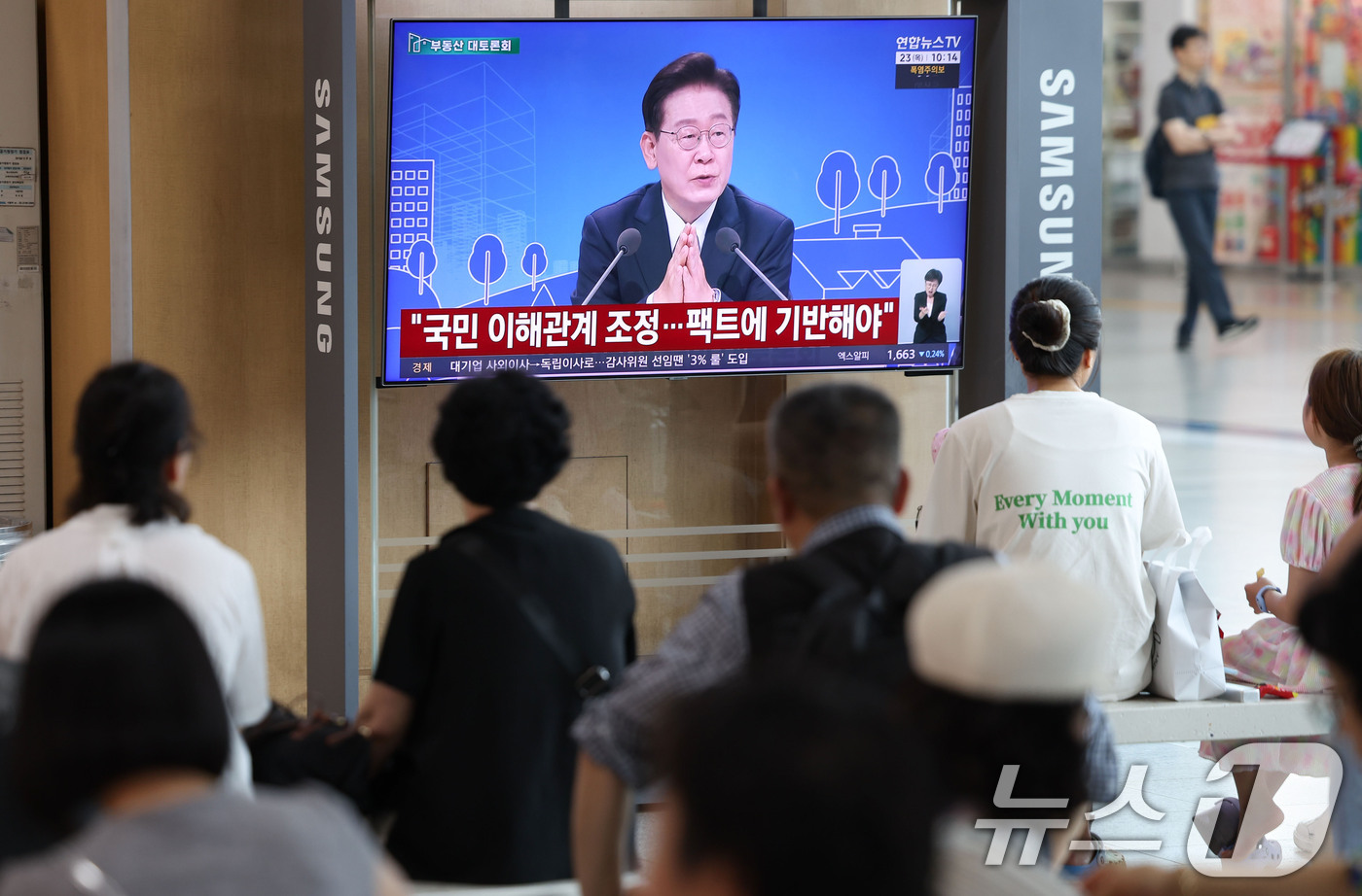 (서울=뉴스1) 이종수 기자 = 23일 오전 서울역 대합실에서 시민들이 이재명 대통령이 주재하는 부동산 대토론회 TV 생중계를 시청하고 있다. 2026.7.23/뉴스1