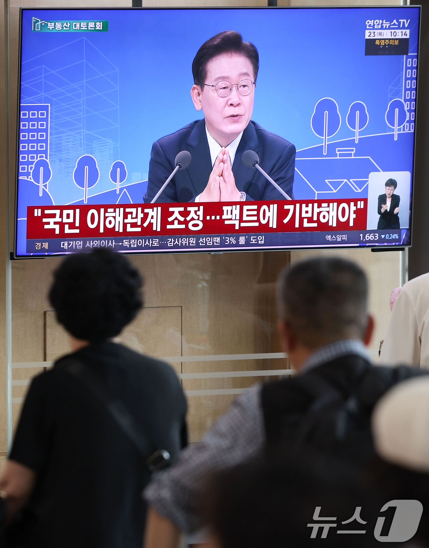 (서울=뉴스1) 이종수 기자 = 23일 오전 서울역 대합실에서 시민들이 이재명 대통령이 주재하는 부동산 대토론회 TV 생중계를 시청하고 있다. 2026.7.23/뉴스1