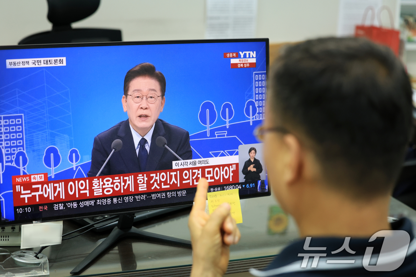 (서울=뉴스1) 이호윤 기자 = 이재명 정부의 부동산 정책 국민 대토론회가 개최된 23일 서울시내의 한 부동산에서 공인중개사가 토론회 생방송을 시청하고 있다. 2026.7.23/뉴 …
