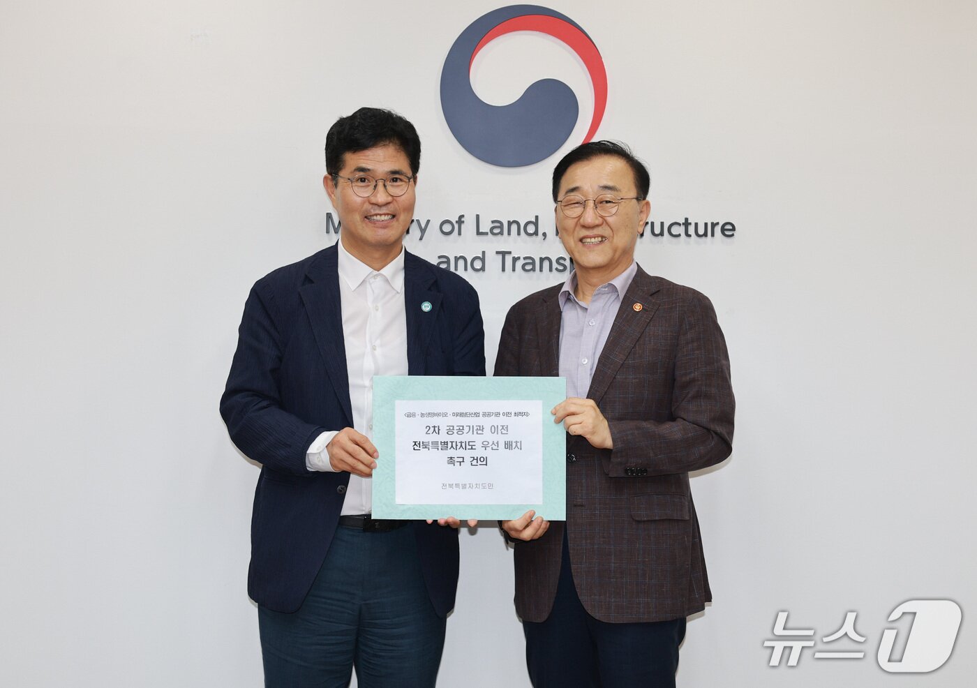 본문 이미지 - 지난 21일 이원택 전북지사(왼쪽)가 김윤덕 국토부 장관에게 '2차 공공기관 이전 시 전북 우선 배치 요청 건의문'을 전달하고 함께 기념 촬영을 하고 있다.(전북도 제공. 재판매 및 DB금지)/뉴스1
