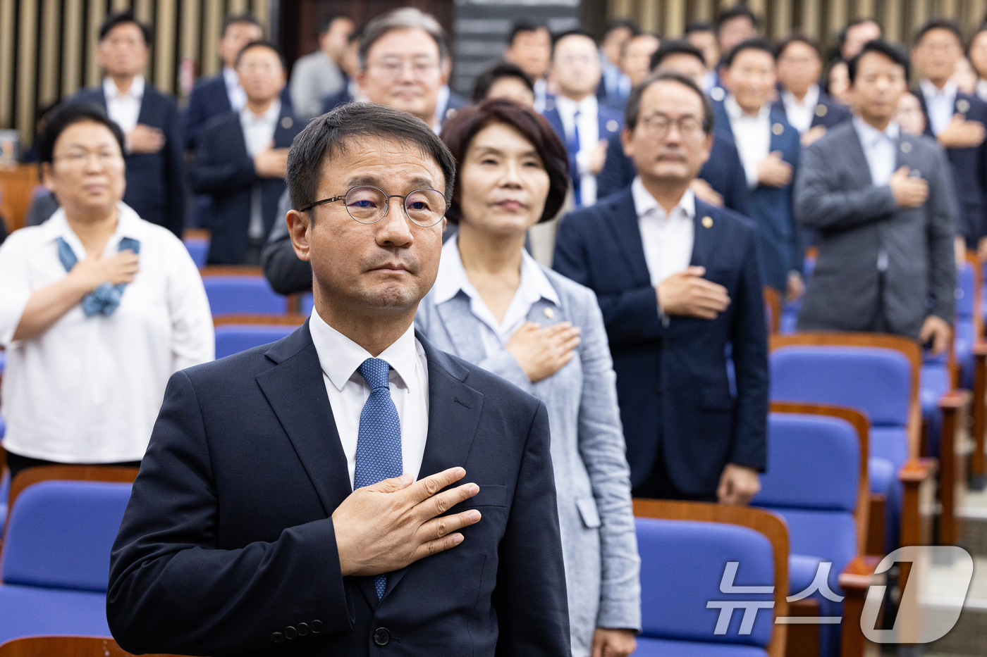 (서울=뉴스1) 유승관 기자 = 한병도 더불어민주당 당대표 직무대행 겸 원내대표를 비롯한 의원들이 23일 서울 여의도 국회에서 열린 의원총회에서 국민의례를 하고 있다. 2026.7 …