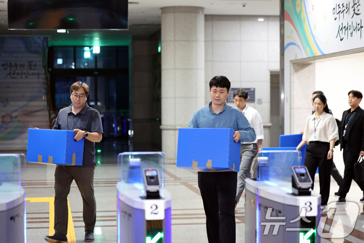 (과천=뉴스1) 이광호 기자 = 6·3 지방선거 투표용지 부족 사태를 수사 중인 검·경 합동수사본부 관계자들이 23일 오후 경기 과천시 중앙선거관리위원회에 대한 압수수색을 마친뒤 …