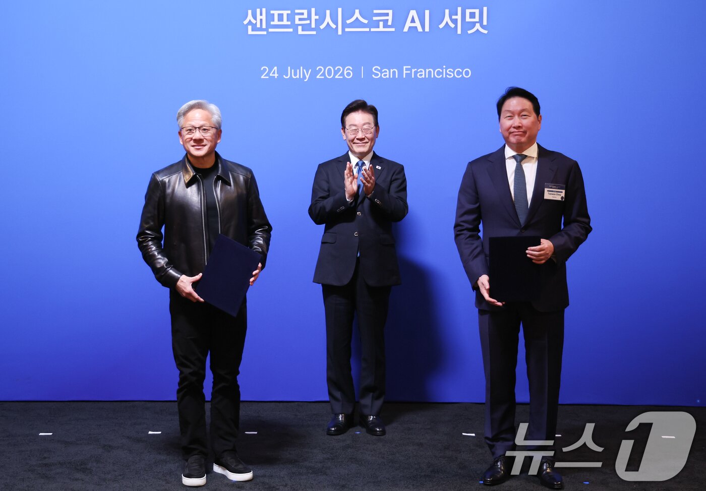 본문 이미지 - 최태원 SK그룹 회장과 젠슨 황 엔비디아 최고경영자가 24일(현지시간) 이재명 대통령이 임석한 가운데 미국 샌프란시스코 더 미드웨이에서 열린 AI 서밋에 앞서 SK하이닉스·SKT와 엔비디아의 전략적 AI 팩토리 및 반도체 협력 MOU를 체결한 뒤 기념촬영을 하고 있다. 2026.7.25 ⓒ 뉴스1 허경 기자