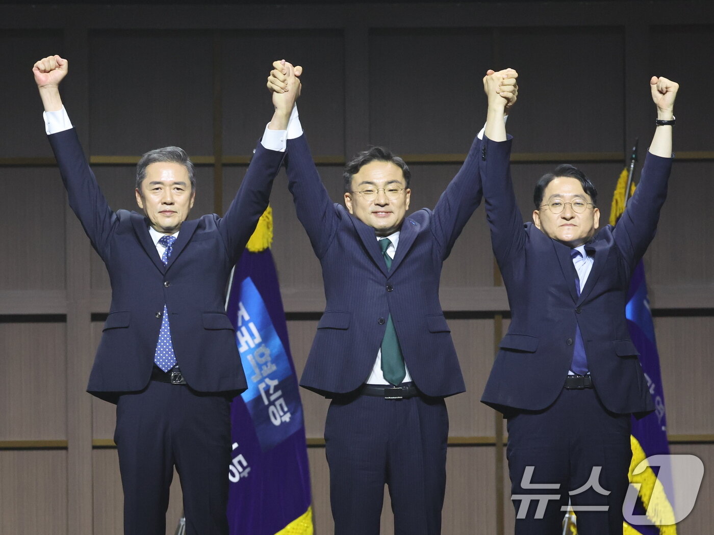 본문 이미지 - 조국혁신당 신임 당대표로 선출된 신장식 의원(가운데)과 신임 최고위원으로 당선된 황현선, 차규근 최고위원이 25일 오후 경기 수원시 수원컨벤션센터에서 열린 2026 전국당원대회에서 두손을 번쩍 들어올리고 있다. 2026.7.25 ⓒ 뉴스1 황기선 기자