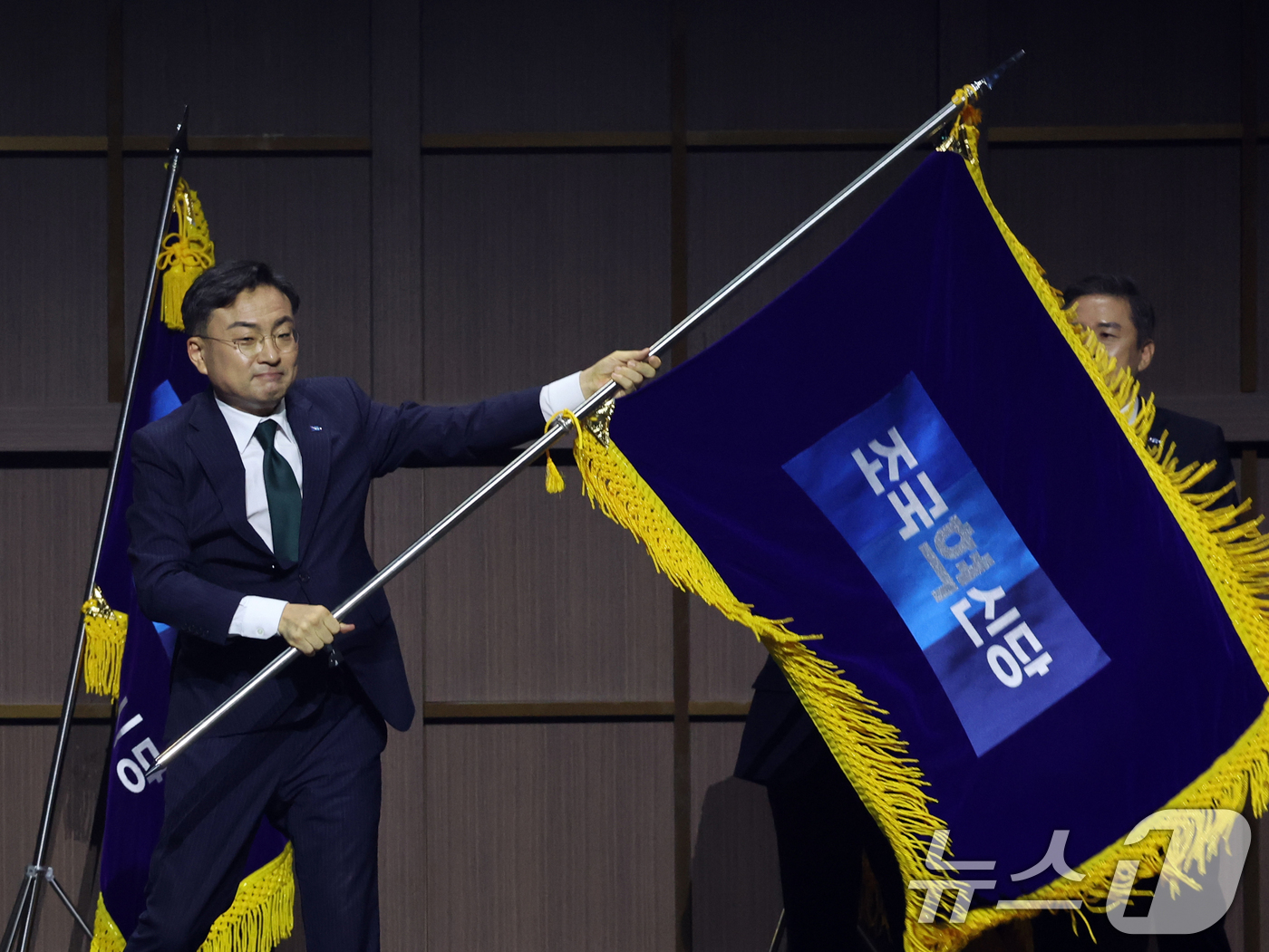 (수원=뉴스1) 황기선 기자 = 조국혁신당 신임 당대표로 선출된 신장식 의원이 25일 오후 경기 수원시 수원컨벤션센터에서 열린 2026 전국당원대회에서 당기를 흔들고 있다.  20 …
