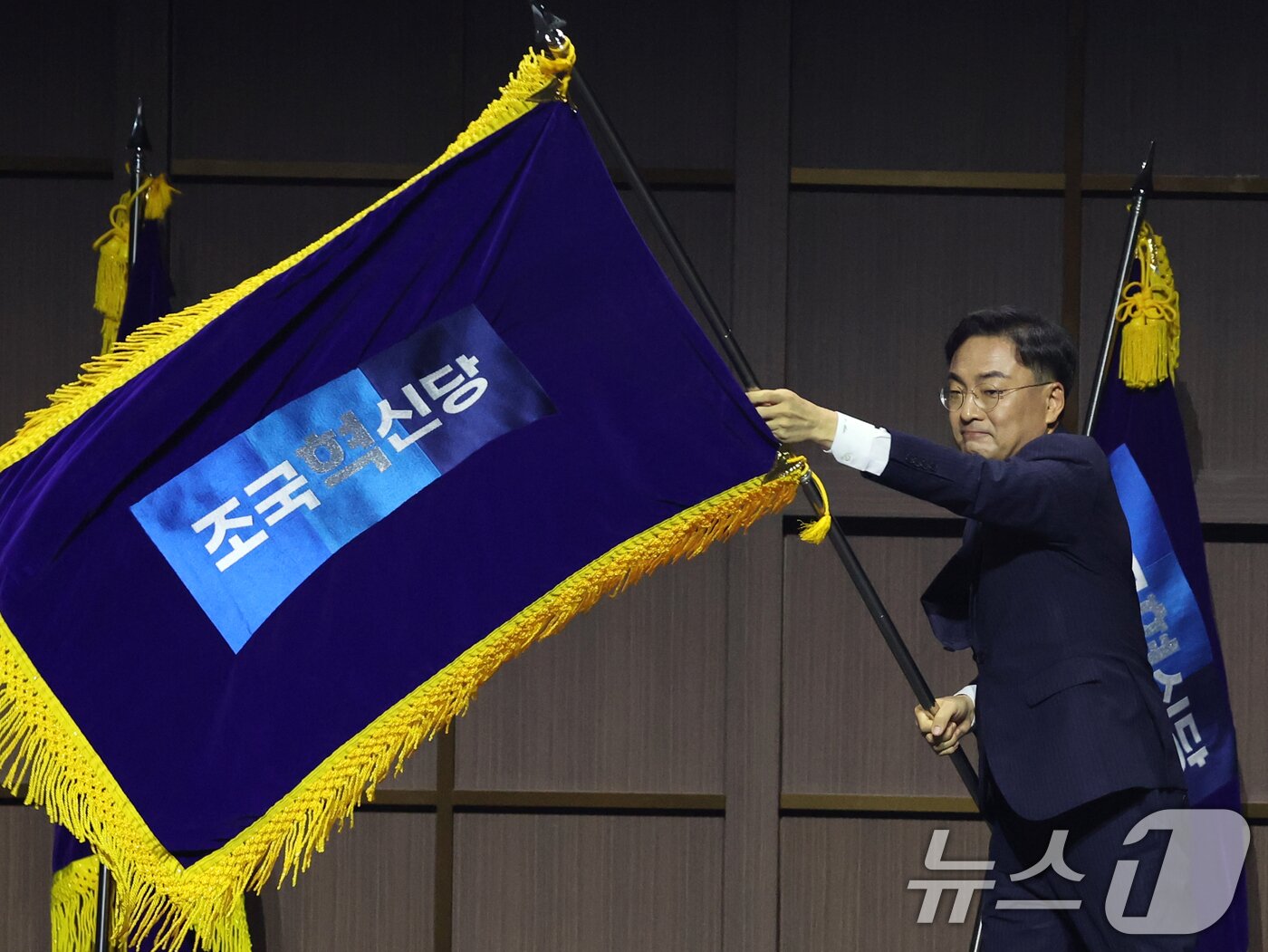 본문 이미지 - 조국혁신당 신임 당대표로 선출된 신장식 의원이 25일 오후 경기 수원시 수원컨벤션센터에서 열린 2026 전국당원대회에서 당기를 흔들고 있다. 2026.7.25 ⓒ 뉴스1 황기선 기자