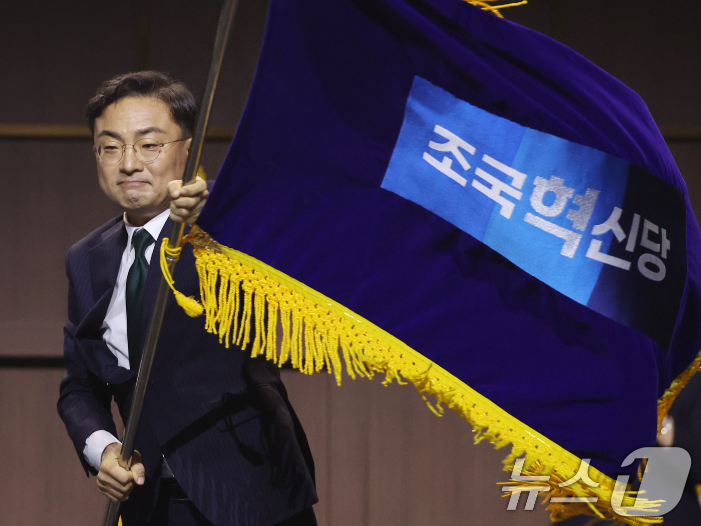 (수원=뉴스1) 황기선 기자 = 조국혁신당 신임 당대표로 선출된 신장식 의원이 25일 오후 경기 수원시 수원컨벤션센터에서 열린 2026 전국당원대회에서 당기를 흔들고 있다.  20 …