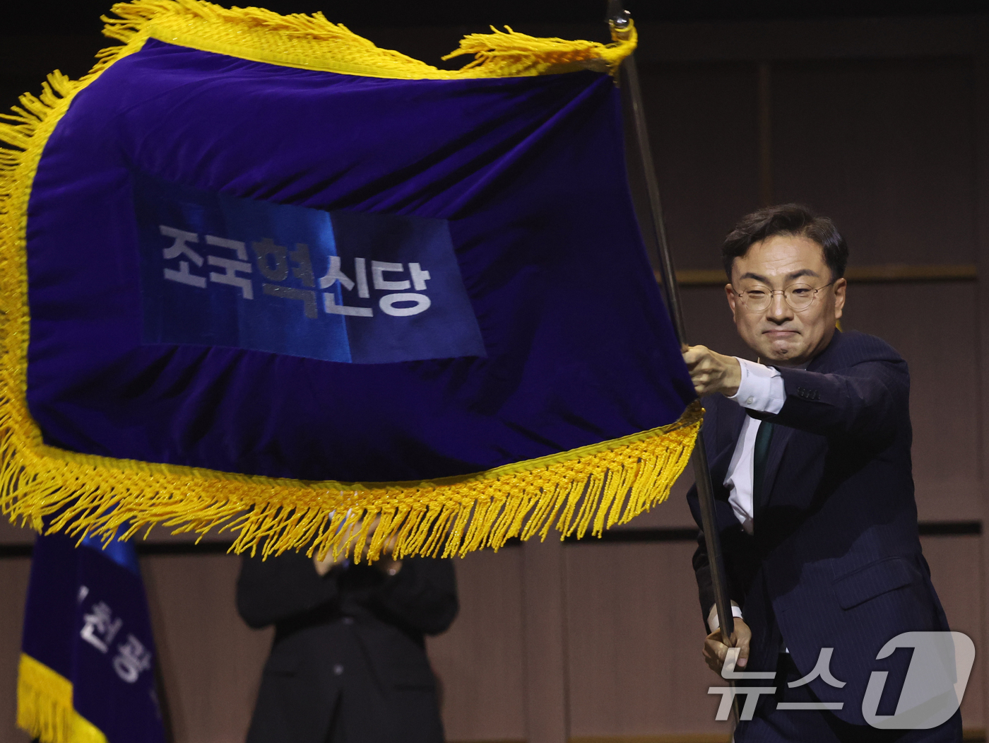 (수원=뉴스1) 황기선 기자 = 조국혁신당 신임 당대표로 선출된 신장식 의원이 25일 오후 경기 수원시 수원컨벤션센터에서 열린 2026 전국당원대회에서 당기를 흔들고 있다.  20 …