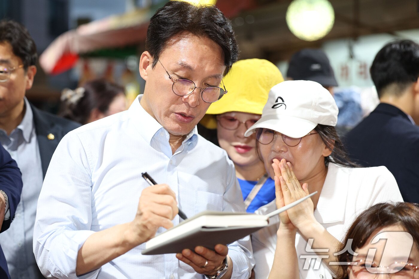 본문 이미지 - 더불어민주당 8·17 전당대회 대표 경선에 진출한 김민석 전 총리가 25일 전남 광주 대인야시장을 찾아 시민에게 사인을 하고 있다. 2026.7.25 ⓒ 뉴스1 이승현 기자