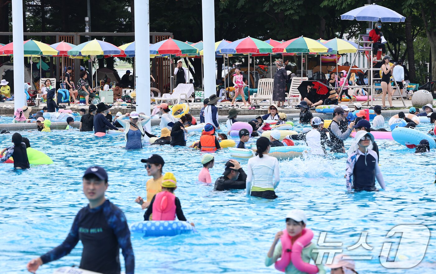 본문 이미지 - 전국 대부분 지역에 폭염이 찾아온 26일 서울 광진구 뚝섬 한강공원 수영장을 찾은 시민들이 물놀이를 하며 더위를 식히고 있다. 2026.7.26 ⓒ 뉴스1 김도우 기자