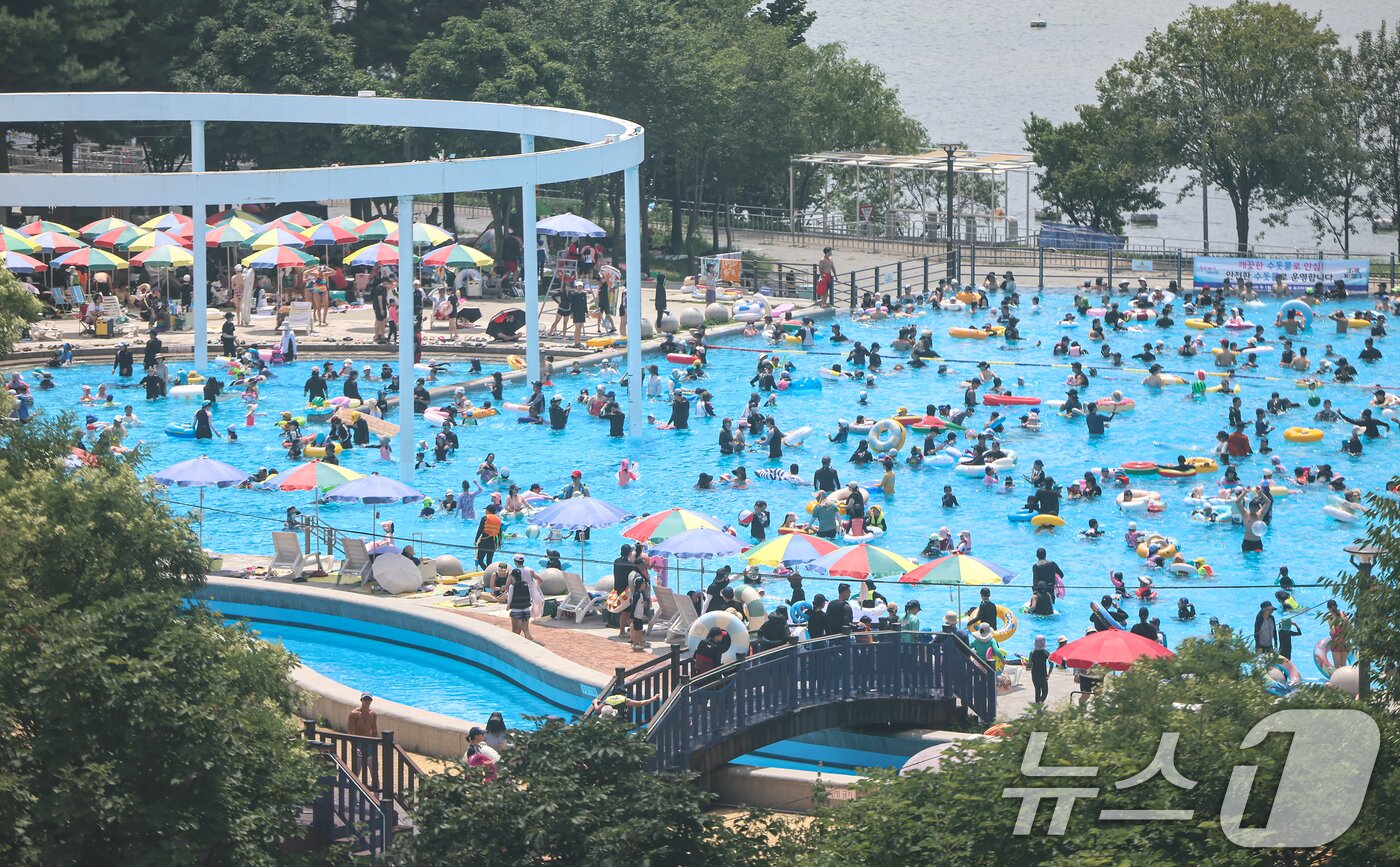 본문 이미지 - 전국 대부분 지역에 폭염이 찾아온 26일 서울 광진구 뚝섬 한강공원 수영장을 찾은 시민들이 물놀이를 하며 더위를 식히고 있다. 2026.7.26 ⓒ 뉴스1 김도우 기자
