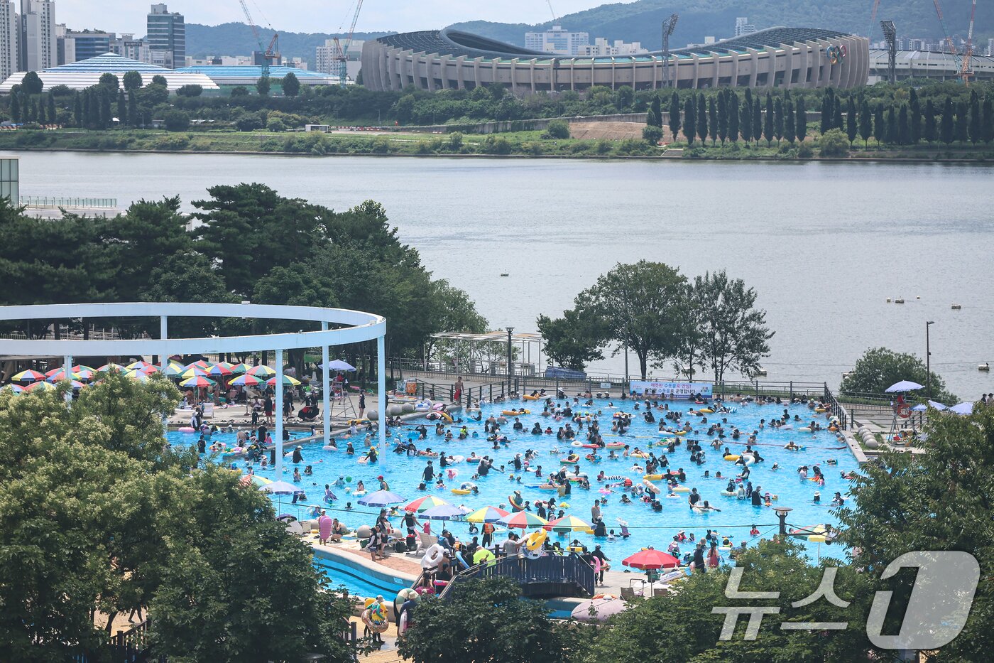 본문 이미지 - 전국 대부분 지역에 폭염이 찾아온 26일 서울 광진구 뚝섬 한강공원 수영장을 찾은 시민들이 물놀이를 하며 더위를 식히고 있다. 2026.7.26 ⓒ 뉴스1 김도우 기자