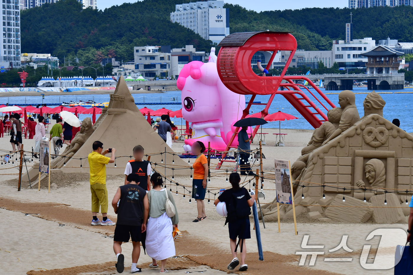 (포항=뉴스1) 최창호 기자 = 26일 경북 포항시 영일대해수욕장에서 시민들과 관광객들이 샌드페스티벌 모래조각 작품과 프린센스 캐치 티피닝 캐릭터를 둘러보고 있다. 2026.7.2 …