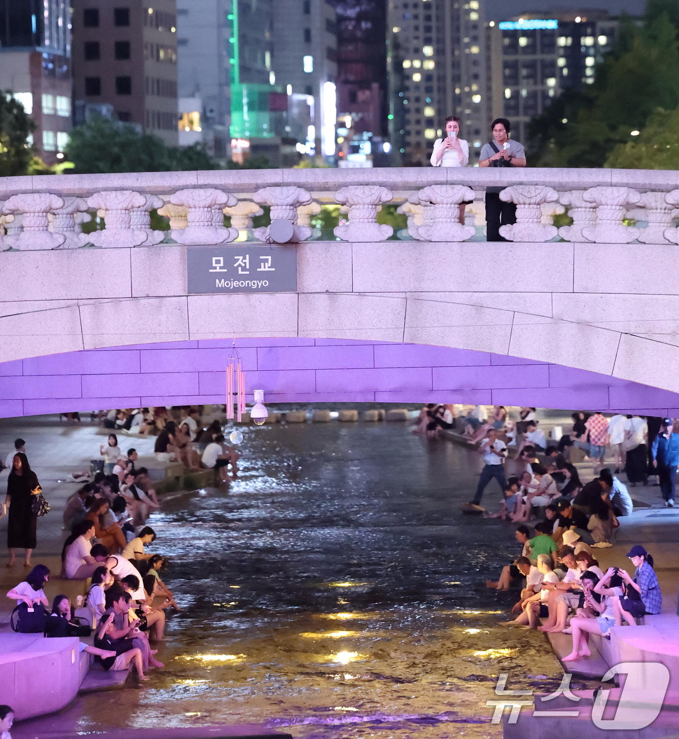 (서울=뉴스1) 오대일 기자 = 서울 전역에 폭염주의보와 열대야주의보가 동시 발효된 26일 저녁 서울 중구 청계천을 찾은 관광객과 시민들이 물가에 앉아 더위를 식히고 있다.기상청이 …