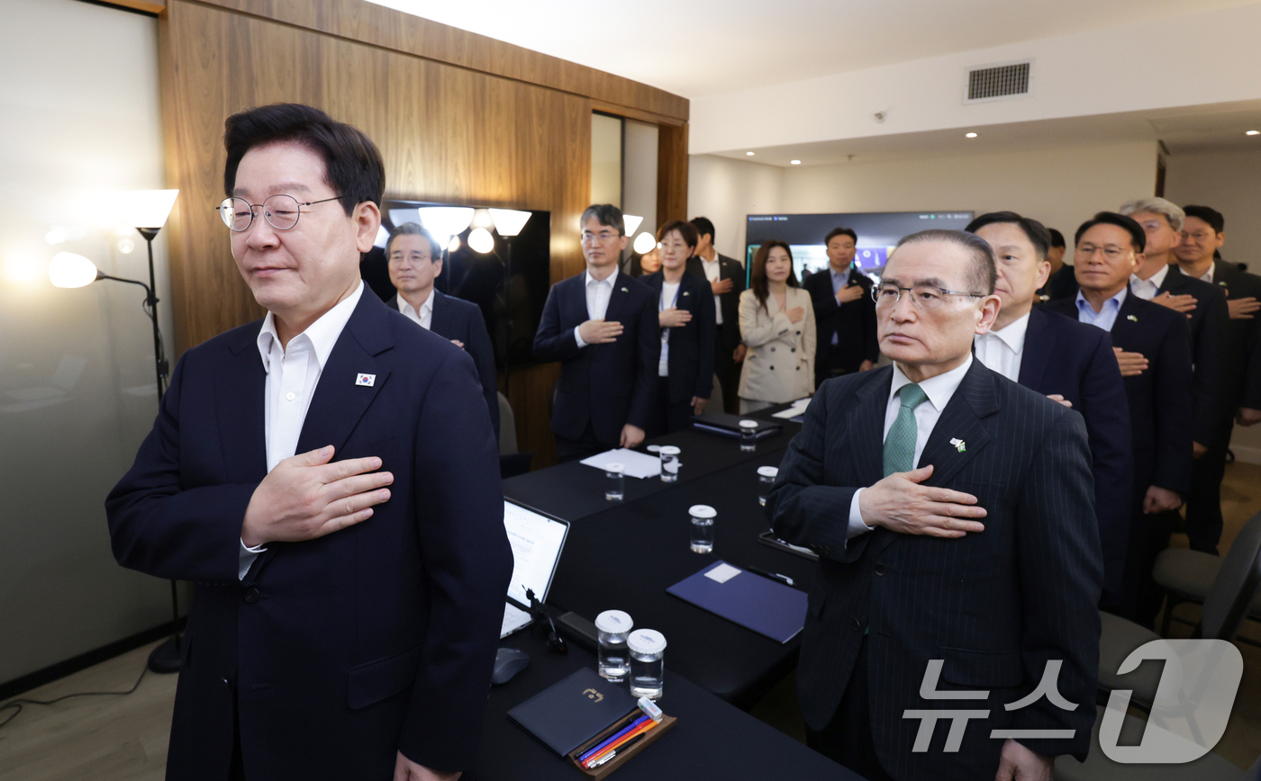 (브라질리아=뉴스1) 허경 기자 = 브라질을 국빈 방문한 이재명 대통령이 26일(현지 시간) 브라질리아에서 화상 수석·보좌관회의에서 국민의례를 하고 있다. 2026.7.27/뉴스1 …