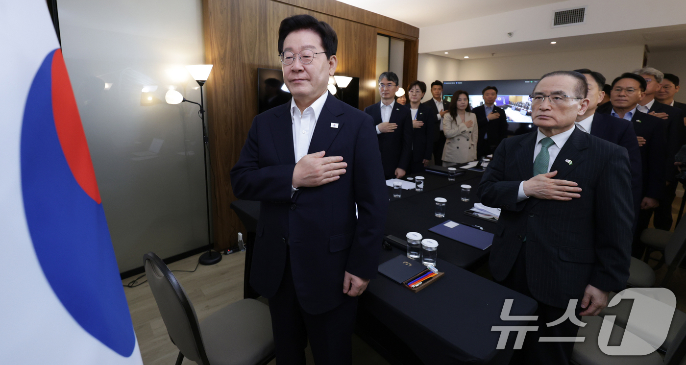 (브라질리아=뉴스1) 허경 기자 = 브라질을 국빈 방문한 이재명 대통령이 26일(현지 시간) 브라질리아에서 화상 수석·보좌관회의에서 국민의례를 하고 있다. 2026.7.27/뉴스1 …