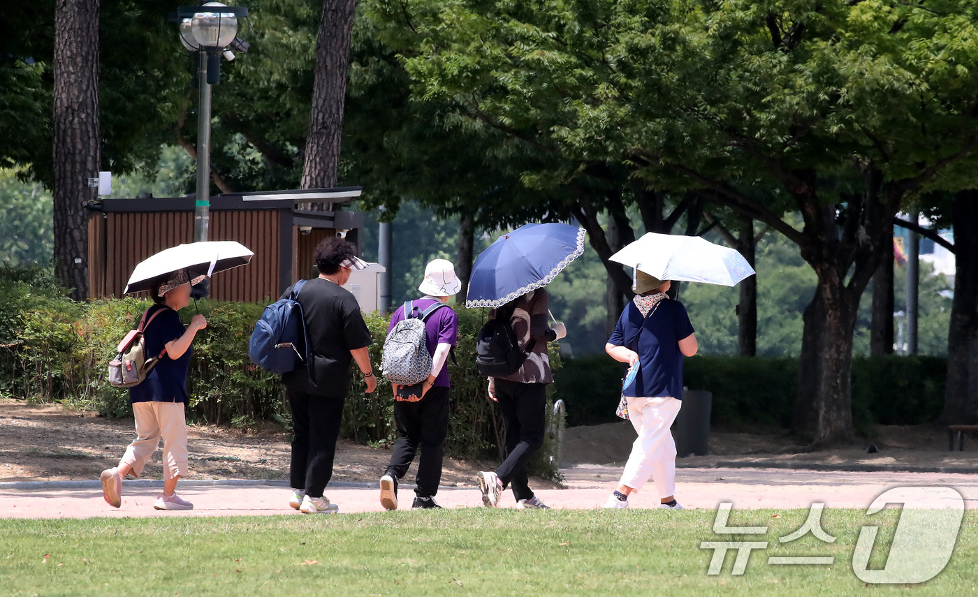 (대구=뉴스1) 공정식 기자 = 폭염이 계속된 27일 대구 수성구 수성못 상화동산에서 시민들이 뙤약볕을 피하기 위해 양산을 쓴 시민들이 발걸음을 옮기고 있다. 2026.7.27/뉴 …
