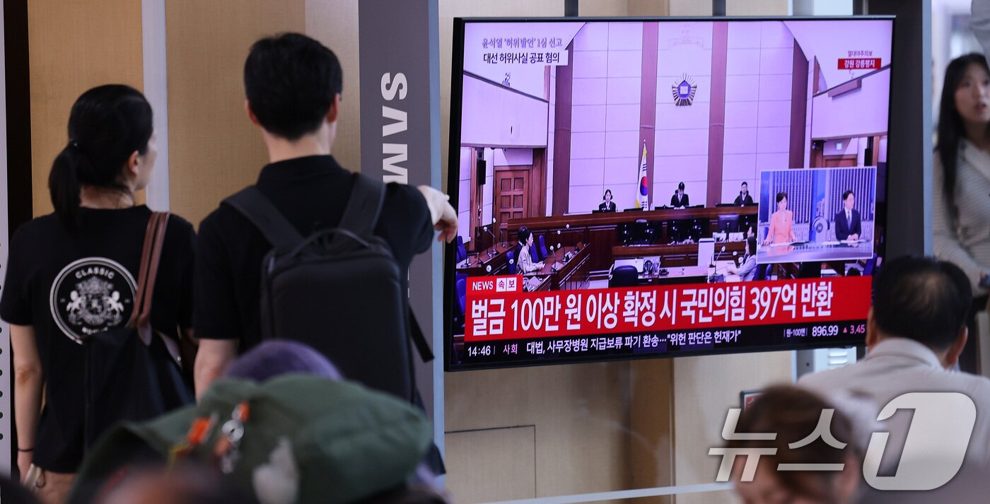본문 이미지 - 27일 서울 용산구 서울역 대합실에서 시민들이 윤석열 전 대통령의 공직선거법 위반 혐의 1심 선고 생중계를 바라보고 있다. 이날 법원은 윤석열에게 징역 1년 6개월에 집행유예 3년을 선고했다. 2026.7.27 ⓒ 뉴스1 박지혜 기자