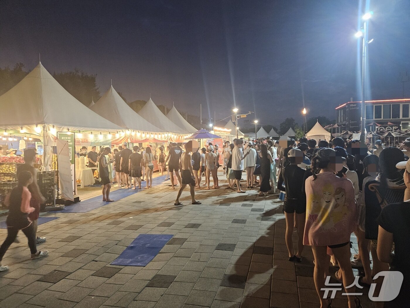 본문 이미지 - 27일 서울 여의도 한강공원 수영장에서 시민들이 물놀이를 즐기고 음식을 파는 부스에 줄을 서는 모습. 2026.7.27 ⓒ 뉴스1 윤지오 수습기자
