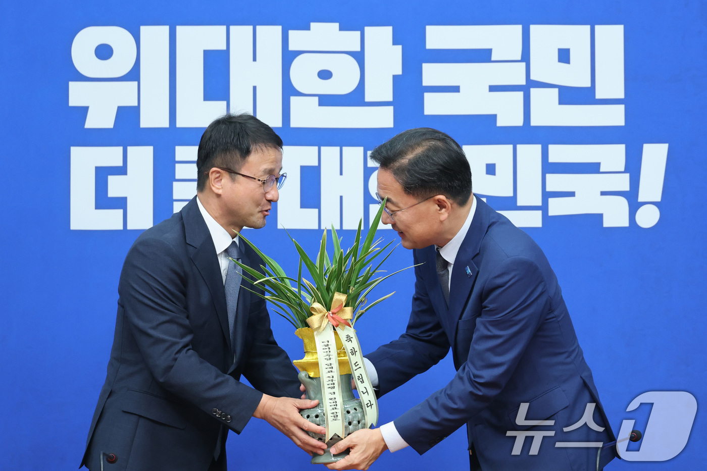 (서울=뉴스1) 신웅수 기자 = 신장식 조국혁신당 대표가 28일 서울 여의도 국회에서 한병도 더불어민주당 대표 직무대행 겸 원내대표를 예방하며 축하난을 선물받고 있다. 2026.7 …