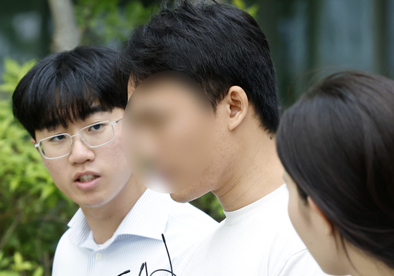 취재진 질문 공세 받는 기자 폭행 시위 참가자