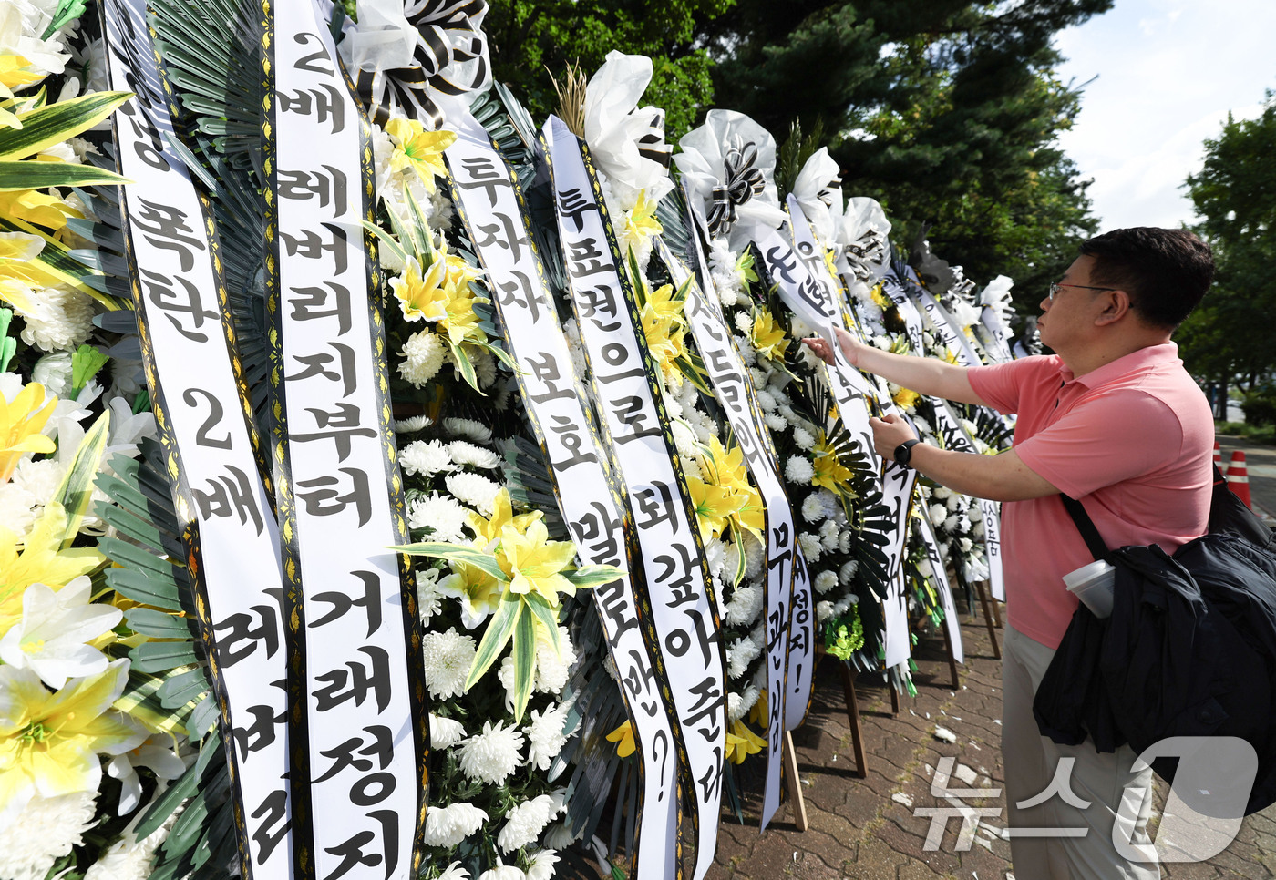 (서울=뉴스1) 이종수 기자 = 29일 서울 여의도 국회의사당 정문 앞에 주식시장 정상화를 위한 모임 관계자가 단일종목 레버리지 ETF 상장 폐지 촉구 근조화환을 설치하고 있다. …