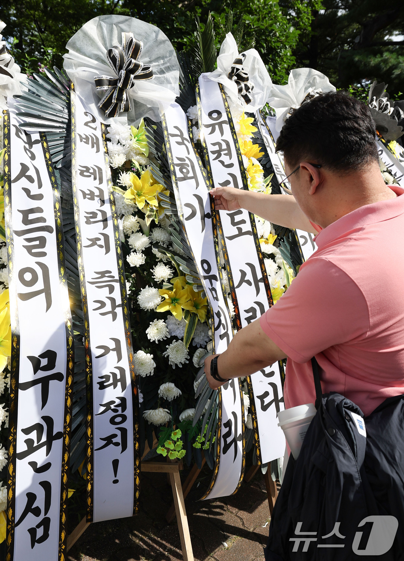 (서울=뉴스1) 이종수 기자 = 29일 서울 여의도 국회의사당 정문 앞에서 주식시장 정상화를 위한 모임 관계자가 단일종목 레버리지 ETF 상장 폐지 촉구 근조화환을 설치하고 있다. …