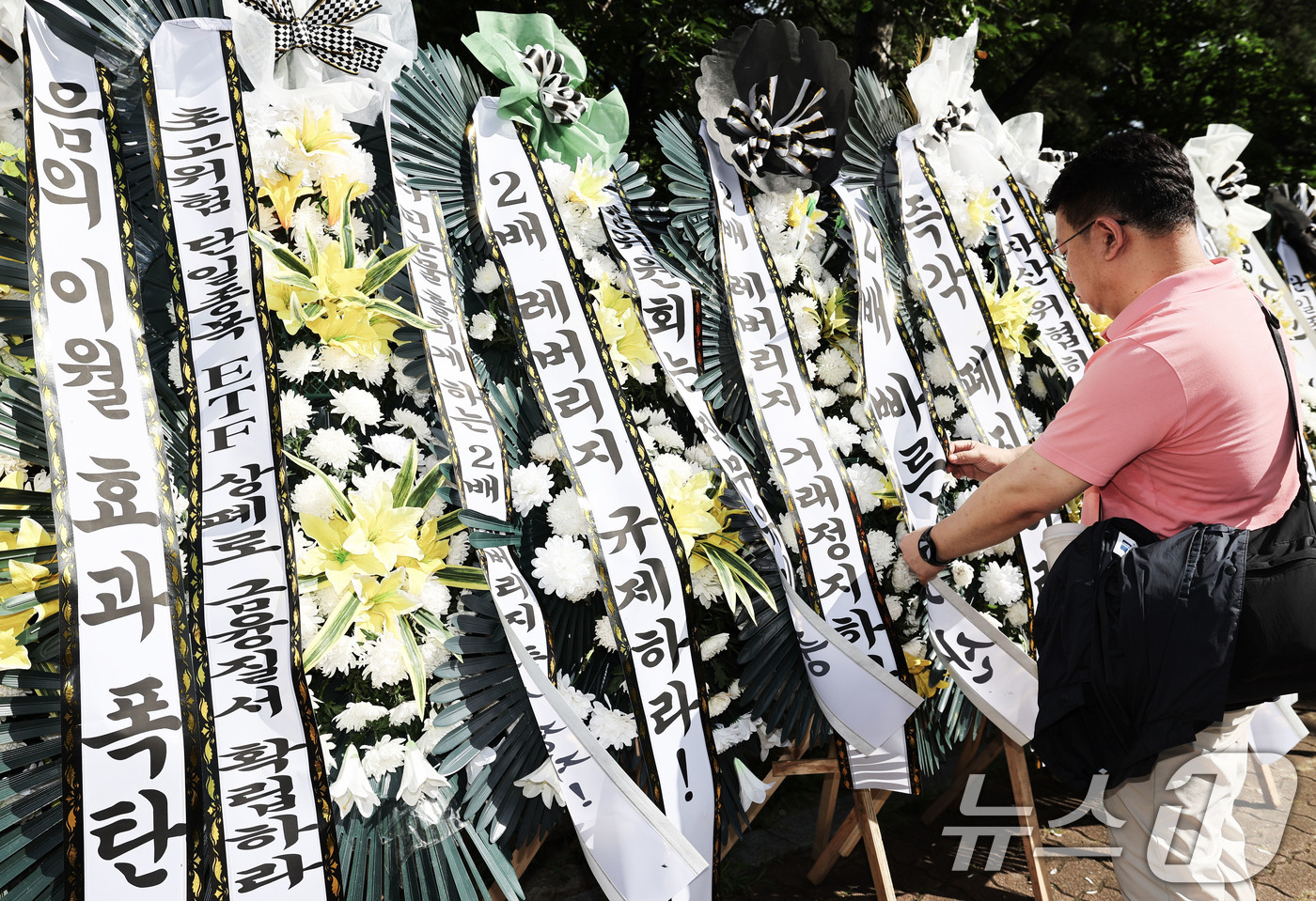 (서울=뉴스1) 이종수 기자 = 29일 서울 여의도 국회의사당 정문 앞에서 주식시장 정상화를 위한 모임 관계자가 단일종목 레버리지 ETF 상장 폐지 촉구 근조화환을 설치하고 있다. …