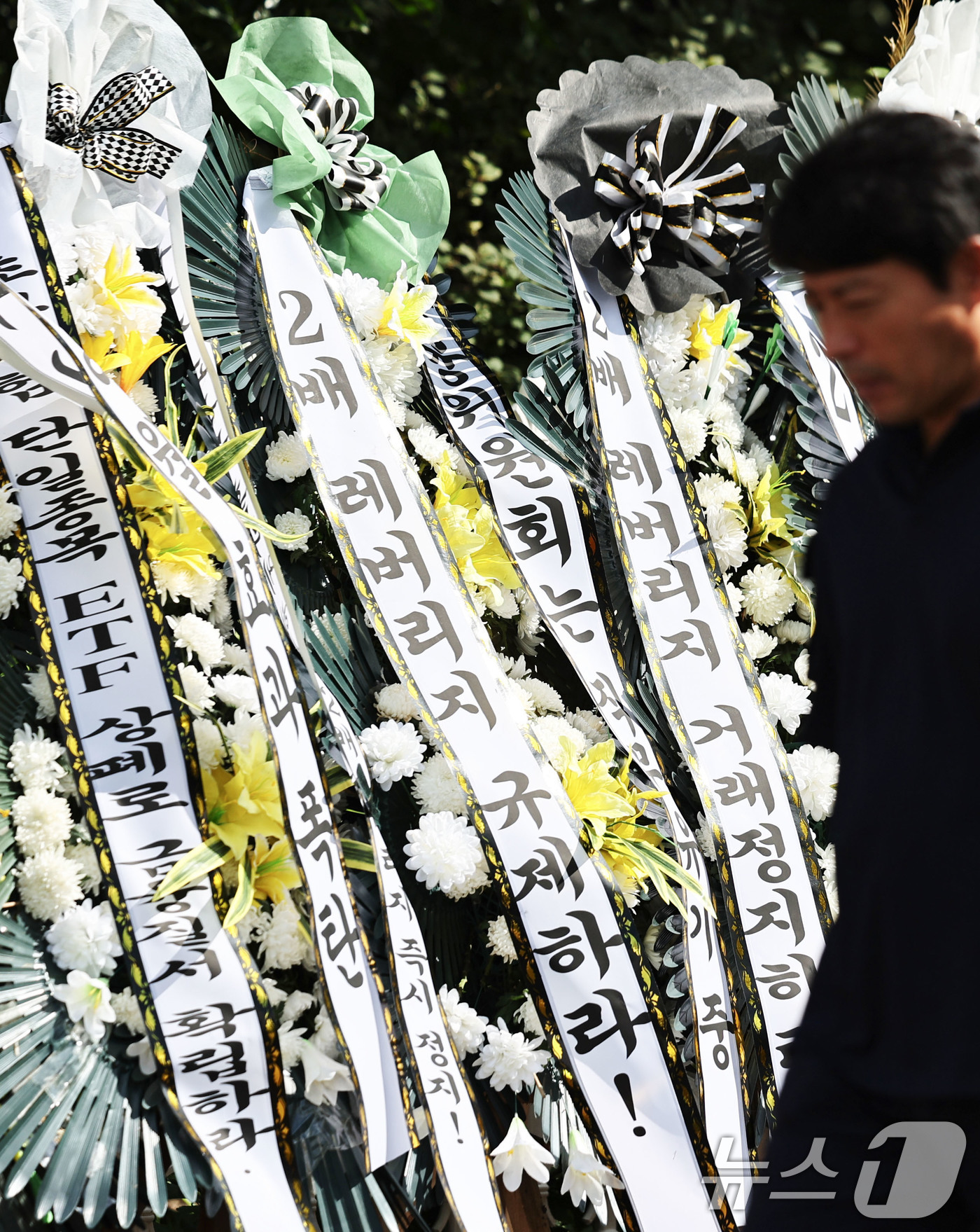 (서울=뉴스1) 이종수 기자 = 29일 서울 여의도 국회의사당 정문 앞에 주식시장 정상화를 위한 모임이 설치한 단일종목 레버리지 ETF 상장 폐지를 촉구 근조화환이 설치돼 있다. …