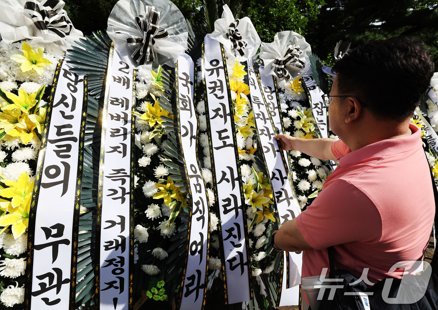(서울=뉴스1) 이종수 기자 = 29일 서울 여의도 국회의사당 정문 앞에서 주식시장 정상화를 위한 모임 관계자가 단일종목 레버리지 ETF 상장 폐지 촉구 근조화환을 설치하고 있다. …