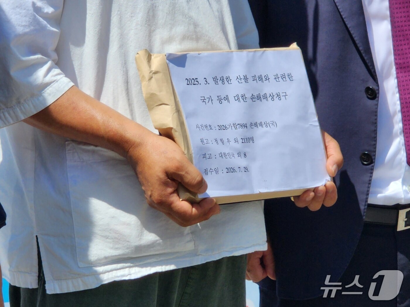 본문 이미지 - 29일 서울중앙지법 앞에서 2025년 경북 산불 피해를 입은 주민들이 산불 초기 진화 실패 및 부실 대응에 대한 국가의 책임을 인정하라며 손해배상 청구 소송을 제기했다. 2026.07.29/ⓒ 뉴스1 권진영 기자
