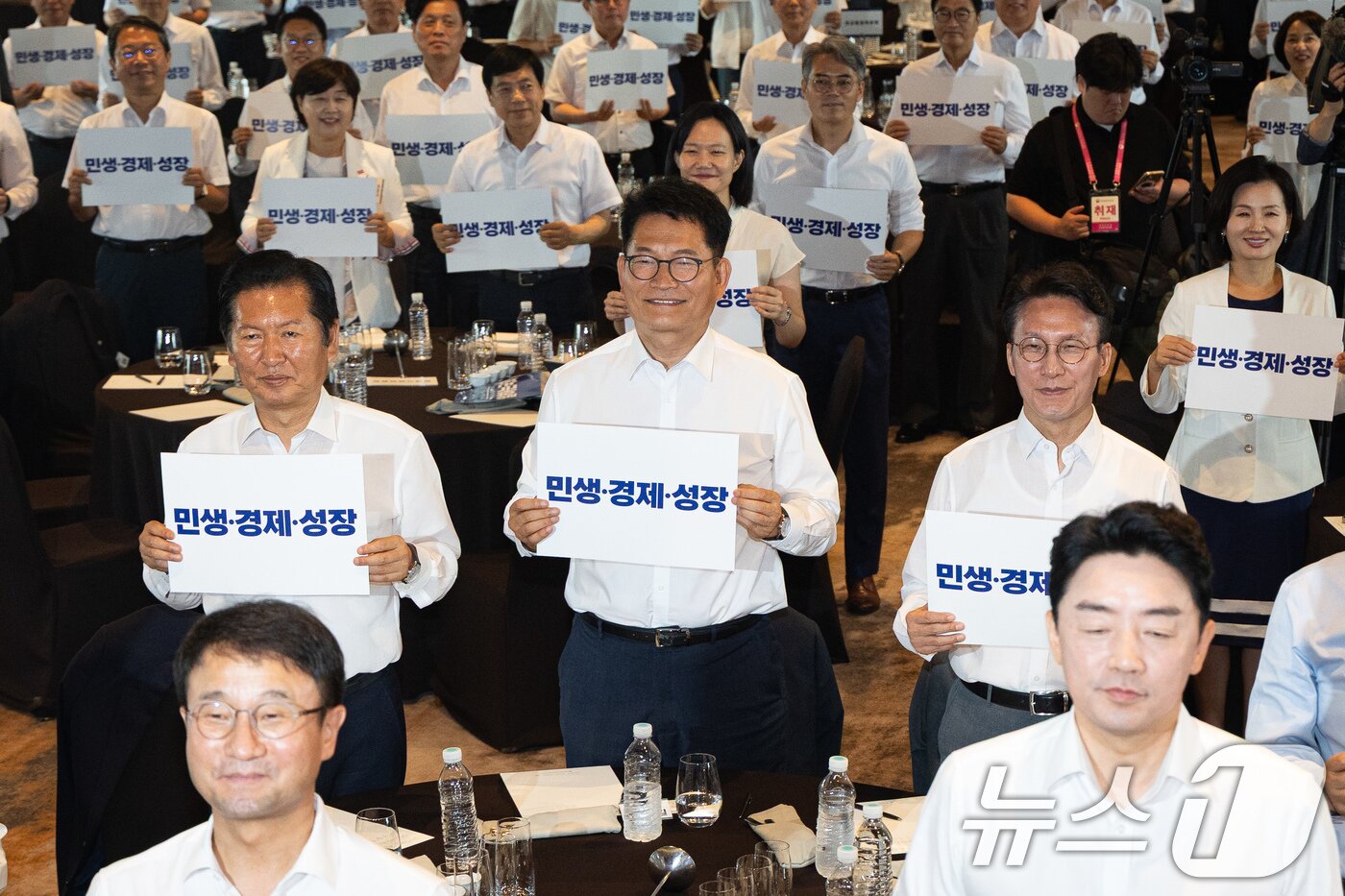 본문 이미지 - 정청래 전 더불어민주당 대표와 송영길 전 대표, 김민석 전 총리를 비롯한 참석자들이 3일 서울 용산구 서울드래곤시티에서 열린 22대 후반기 국회 대비 더불어민주당 국회의원 워크숍에서 손팻말을 들고 구호를 외치고 있다. 2026.7.3 ⓒ 뉴스1 유승관 기자