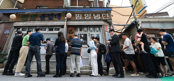 '냉면집 앞 길게 늘어 선 줄'