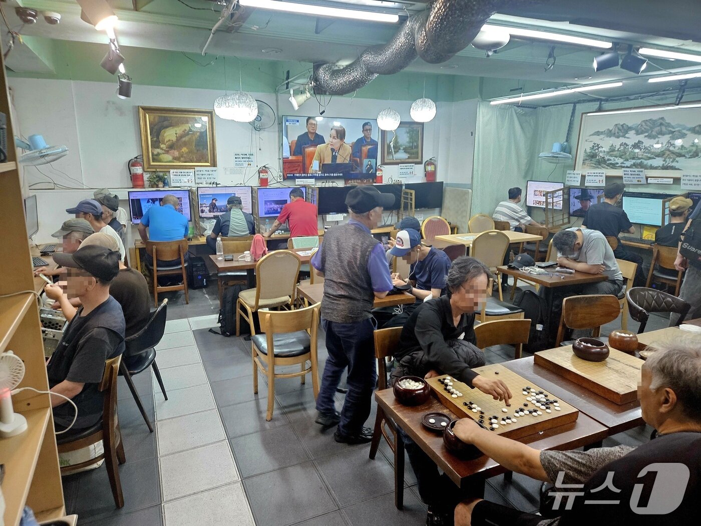 본문 이미지 - 30일 오전 서울역 인근 쉼터 드림씨티에 노숙인들이 앉아 바둑을 두고 있다. 2026.7.30 ⓒ 뉴스1 윤지오 수습기자