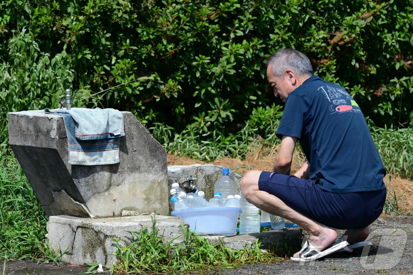(야쓰시로 AFP=뉴스1) 권대옥 수습기자 = 30일 일본 구마모토현 야쓰시로시에서 강진 여파로 단수가 이어진 가운데 한 주민이 공원 수돗가에서 페트병에 물을 채우고 있다. 일본 …