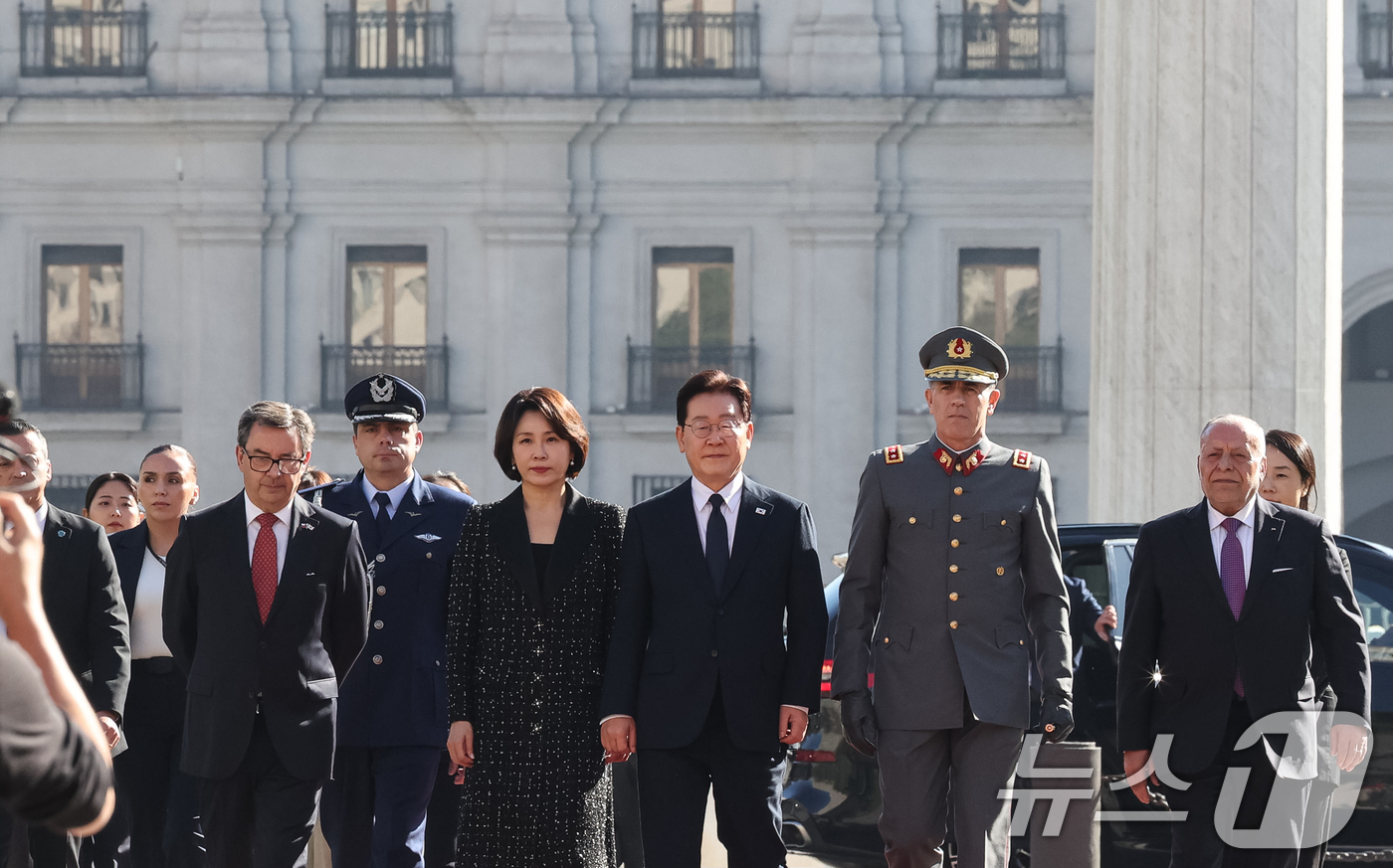 (산티아고(칠레)=뉴스1) 허경 기자 = 이재명 대통령과 김혜경 여사가 30일(현지시간) 칠레 산티아고 건국영웅 오히긴스 동상을 찾아 헌화하기 위해 이동하고 있다. 2026.7.3 …