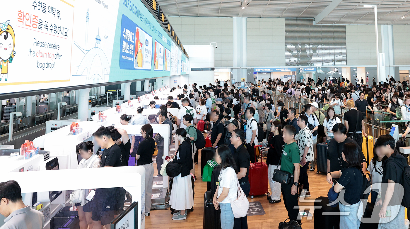 (인천공항=뉴스1) 권현진 기자 = 본격적인 여름 휴가철이 시작된 31일 인천국제공항 제2여객터미널 출국장이 여행객들로 붐비는 가운데, 여행객들이 셀프백드롭 서비스를 이용해 수하물 …